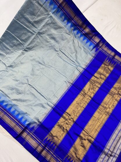 Ilkal saree displayed fully, showcasing the striking blue hues, signature contrast pallu, and intricate golden zari detailing.