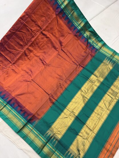 Rich burnt orange and teal green Ilkal saree with gold zari temple border and signature Tope Teni pallu.