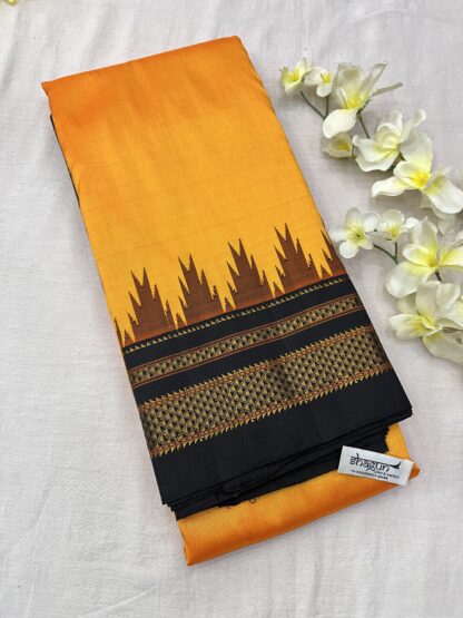 Pure silk saree in vibrant sunset orange and midnight black with intricate golden zari detailing and temple-inspired motifs.