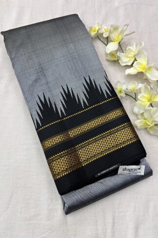 A stunning Grey and Black Pure Silk Ilkal Saree with a temple-inspired gold zari border, neatly folded and adorned with floral accents.