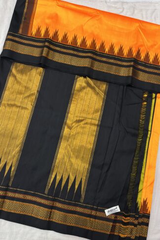 Fully spread pure silk saree in sunset orange and midnight black, showcasing intricate golden zari work, temple border design, and a grand woven pallu.