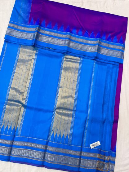 Traditional Ilkal silk saree with golden and silver zari pallu in a striking magenta-blue combination.